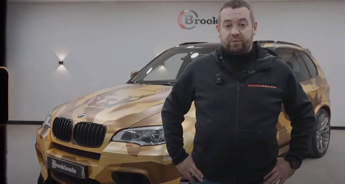 Эрик Давидыч на фоне золотого кроссовера BMW X5M, которого продал для оказания помощи фронту. Фото: кадр из видео.📷
