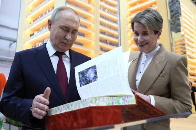    Президент РФ Владимир Путин осматривает выставочное пространство «Международный аэропорт Всемирного фестиваля молодежи» на федеральной территории «Сириус». Справа: руководитель образовательного центра «Сириус», председатель Совета федеральной территории «Сириус» Елена Шмелёва. Фото:  РИА Новости/ Михаил Метцель