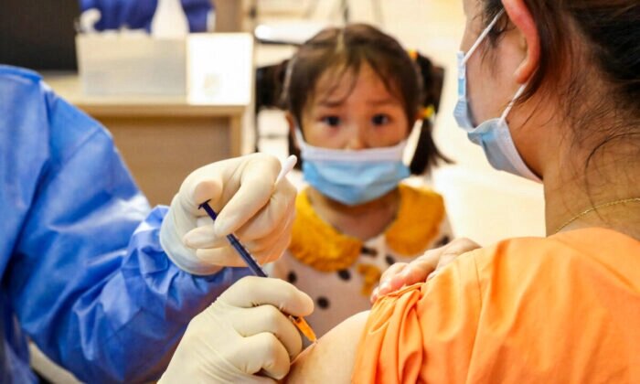 Женщина получает вакцину против COVID-19 от China National Biotec Group (CNBG) в Наньтуне, восточная провинция Китая Цзянсу, 5 июля 2021 года. (STR/AFP via Getty Images)