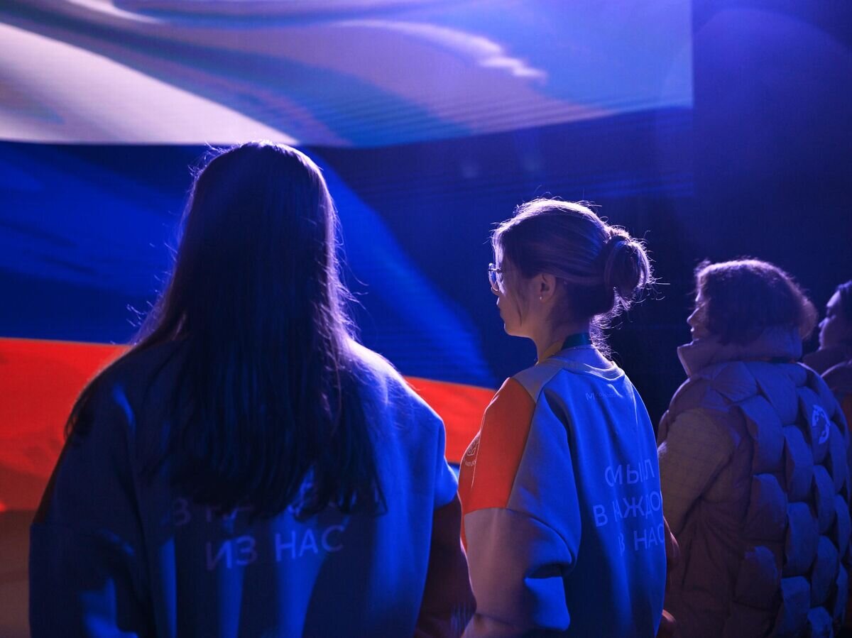    Люди на фоне флага России© РИА Новости / Павел Бедняков