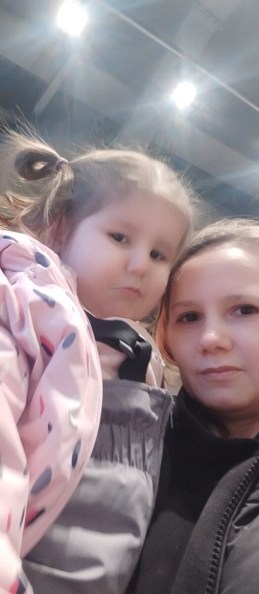 Недовольная. Уже устала гулять по магазинам забралась на ручки. 
