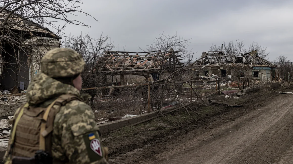 Украинский солдат идет возле дома, разрушенного в результате российского обстрела 23 февраля © Diego Herrera Carcedo/Anadolu/Getty Images
