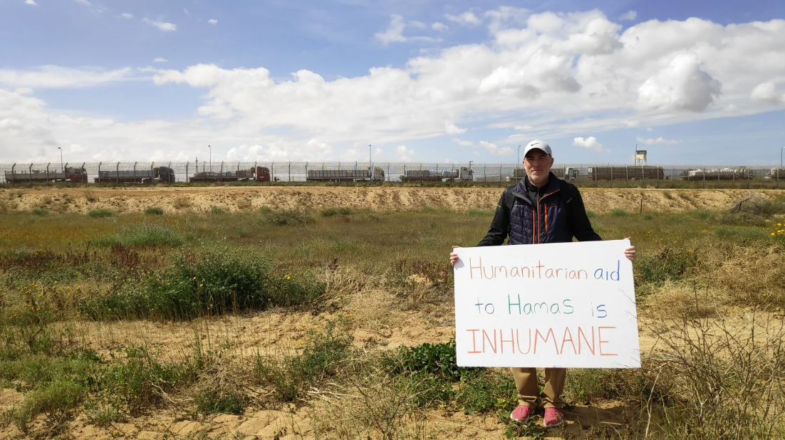 Майкл Раскас на границе с Газой. Его плакат гласит: «Гуманитарная помощь ХАМАСу бесчеловечна» © Шани Бар-Давид