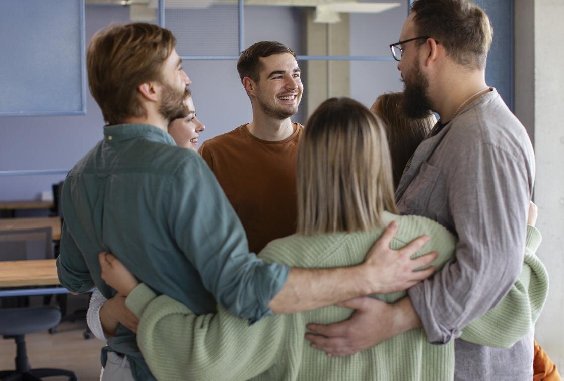    Коллеги обнимают друг друга:Freepik