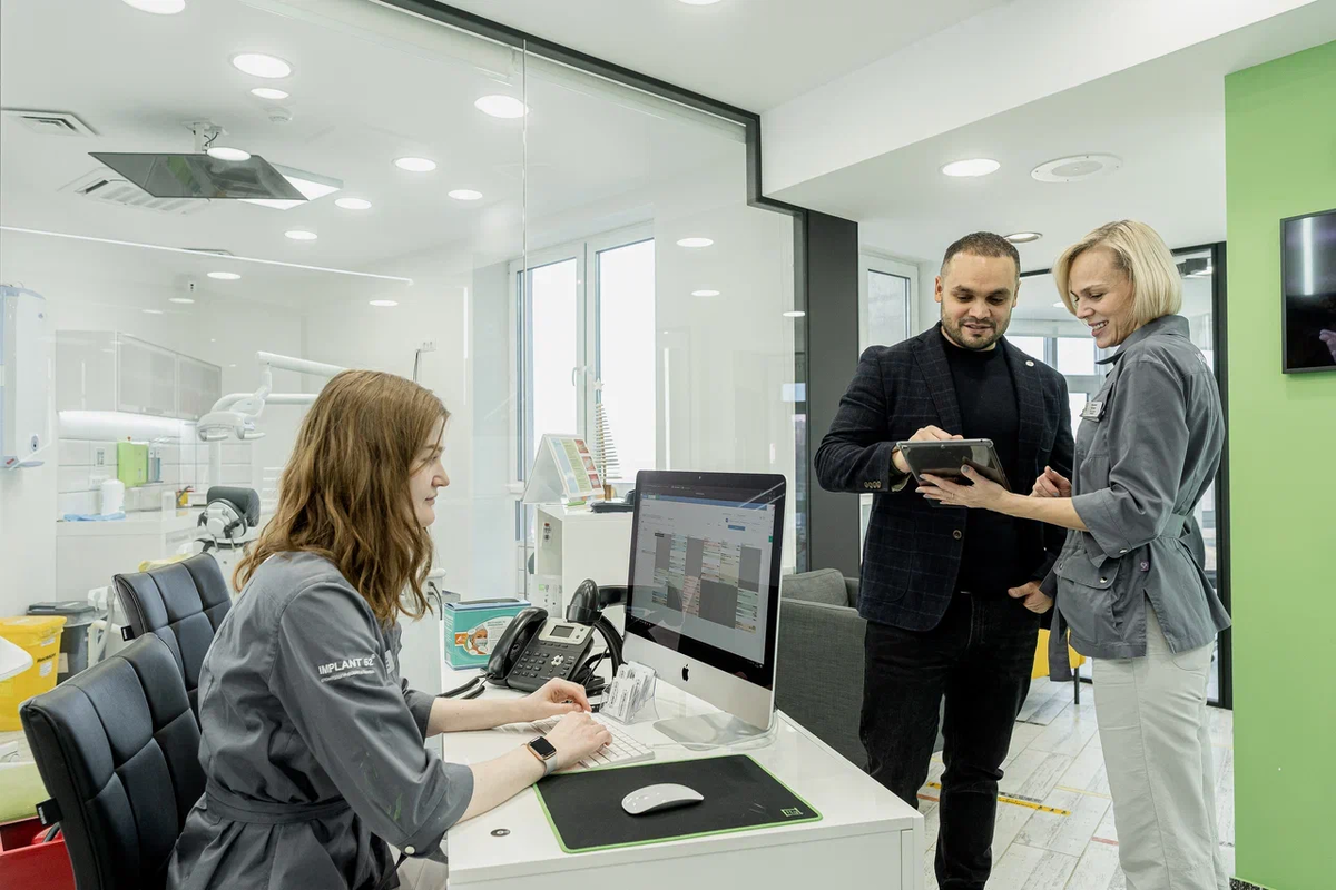 Куратор лечения показывает пациенту как пользоваться приложением клиники