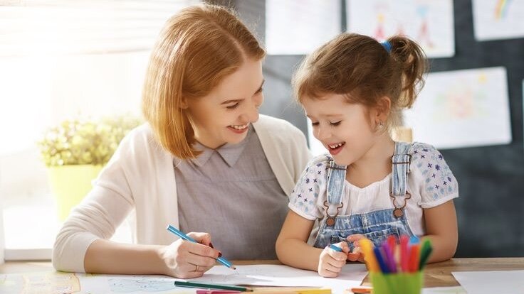 Мама показывает дочери, как нарисовать жирафа