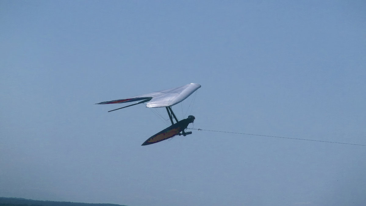 Дельтапланерист летит на буксире