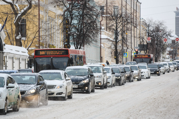 Автомобили и красные автобусы на улице Казани