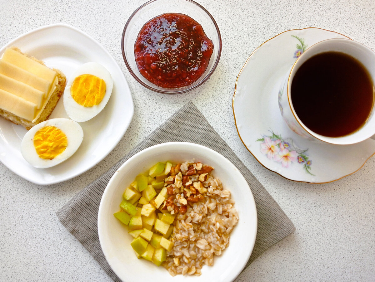 Овсянка с орехами и яблоками, вареные яйца, хлеб с маслом и сыром. Чай и малиновое варенье.