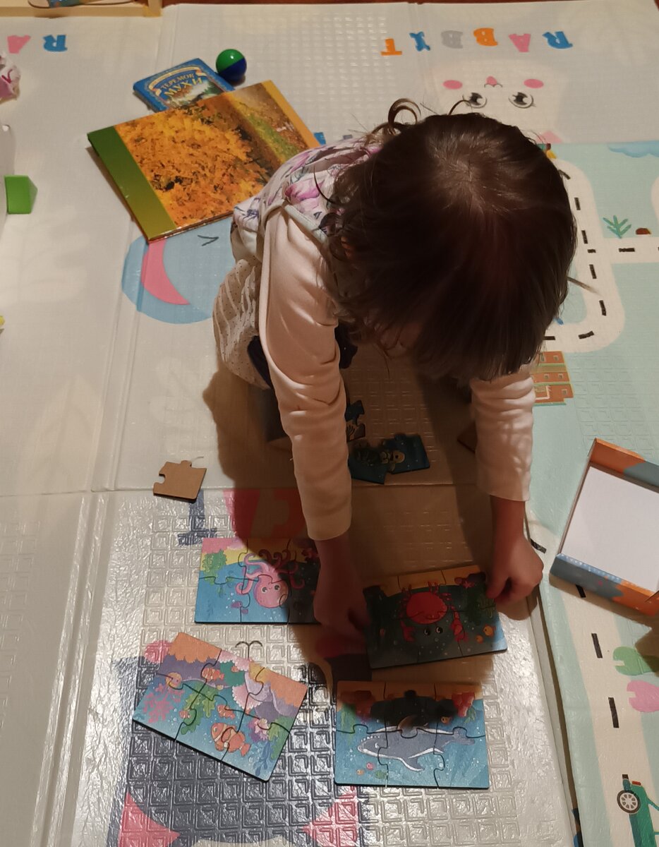 Дочь пробует собирать пазлы. Фото автора