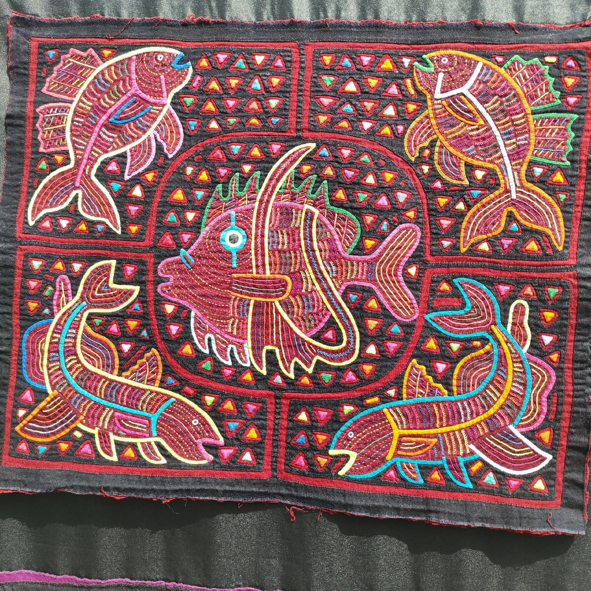 Мола. Декоративный элемент одежды племени Куна - индейцев островов Карибского моря.  Фото сделано на выставке "Шедевры лоскутного шитья". Москва, Гостинный двор, июль 2022 год