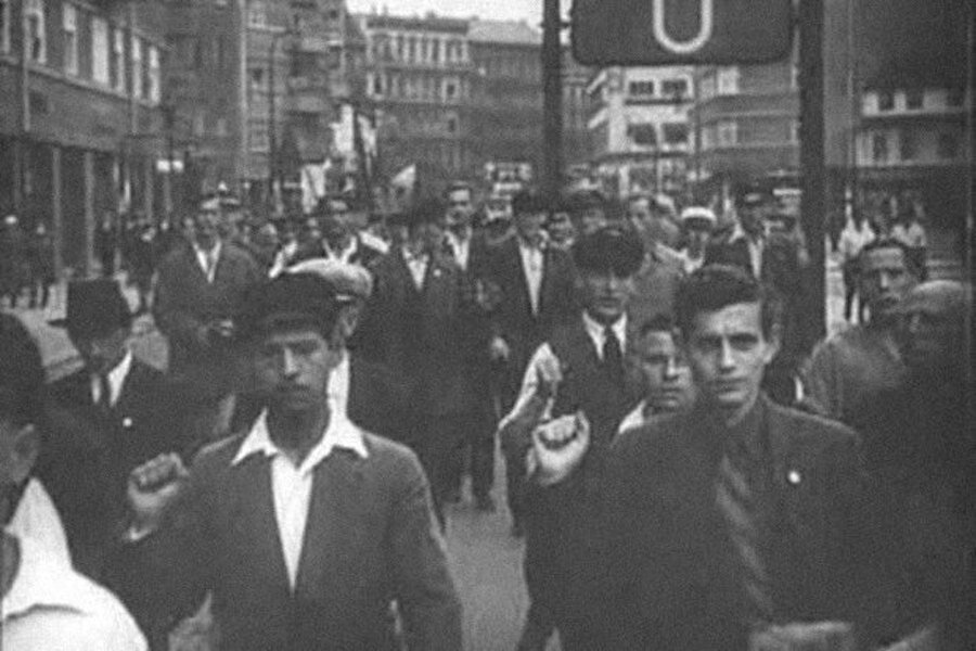 Демонстрация в Берлине, начало 30-х. Участники идут, подняв правую руку и сжав её в кулак в знак принадлежности к антифашистскому движению