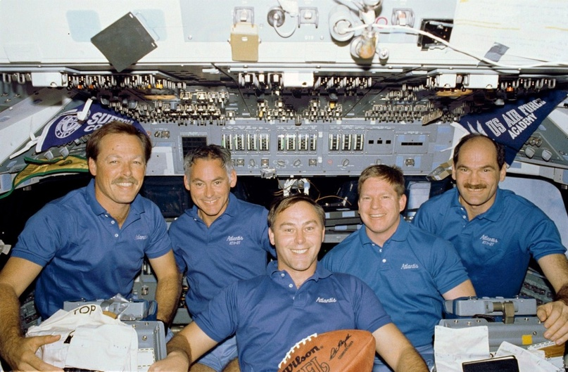 2 декабря 1988 года. Экипаж миссии STS-27 на полетной палубе шаттла "Атлантис": Robert L. Gibson, Richard М. Mullane, Jerry L. Ross, William M. Shepherd, Guy S. Gardner. В январе 1988 года, в перерыве Суперкубка по футболу, NASA предстояло чествование и было решено передать председателю Национальной футбольной лиги футбольный мяч, летавший в космос на шаттле. Мяч привезли сдутым, чтобы он занимал меньший объем, но командир корабля Роберт "Хут" Гибсон сумел слегка подкачать его, используя шприц для подачи воды в пакеты с обезвоженной пищей.