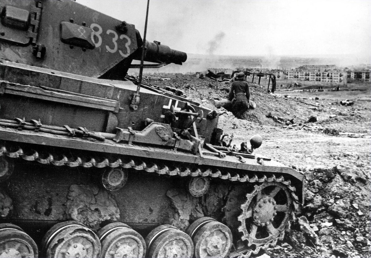 Немецкий танк Pz.Kpfw.IV с бортовым номером №833 из 14 тд (видна эмблема дивизии на башне) в наступлении на поселок СТЗ. Октябрь 1942 года. 