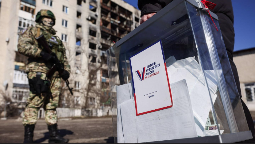 Урна для голосования проносится мимо вооружённого солдата во время досрочного голосования на выборах президента России в 2024 году. Выборы назначены на 15-17 марта © Александр Река / Imago Images