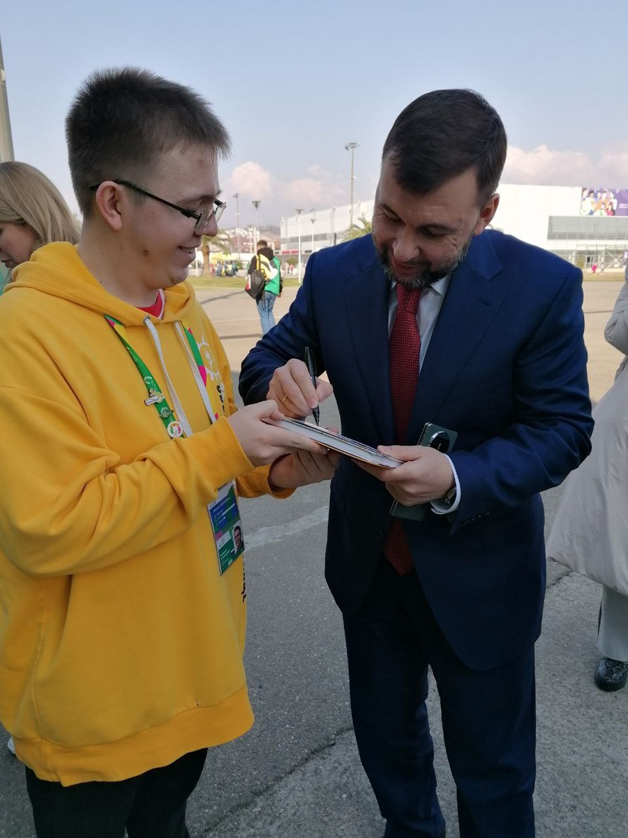 Денис Пушилин подписывает фотокарточку