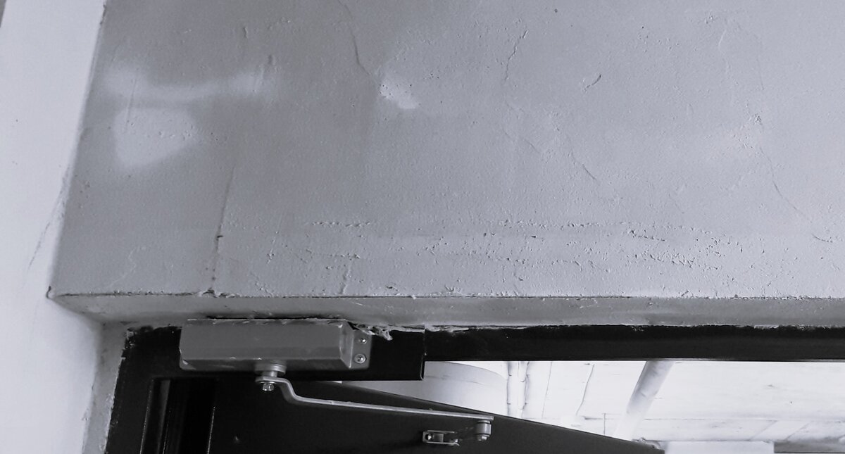 Противопожарная дверь с устройством для самозакрывания, установленная в противопожарной перегородке