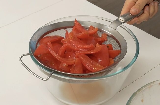 1. Помидоры нарезать дольками, избавить от семян, переложить в миску, посолить, перемешать и оставить на 10 минут. Затем, воспользовавшись ситом, избавиться от выделившегося сока. Повторить эту процедуру еще два раза, после чего полить их оливковым маслом и перемешать.