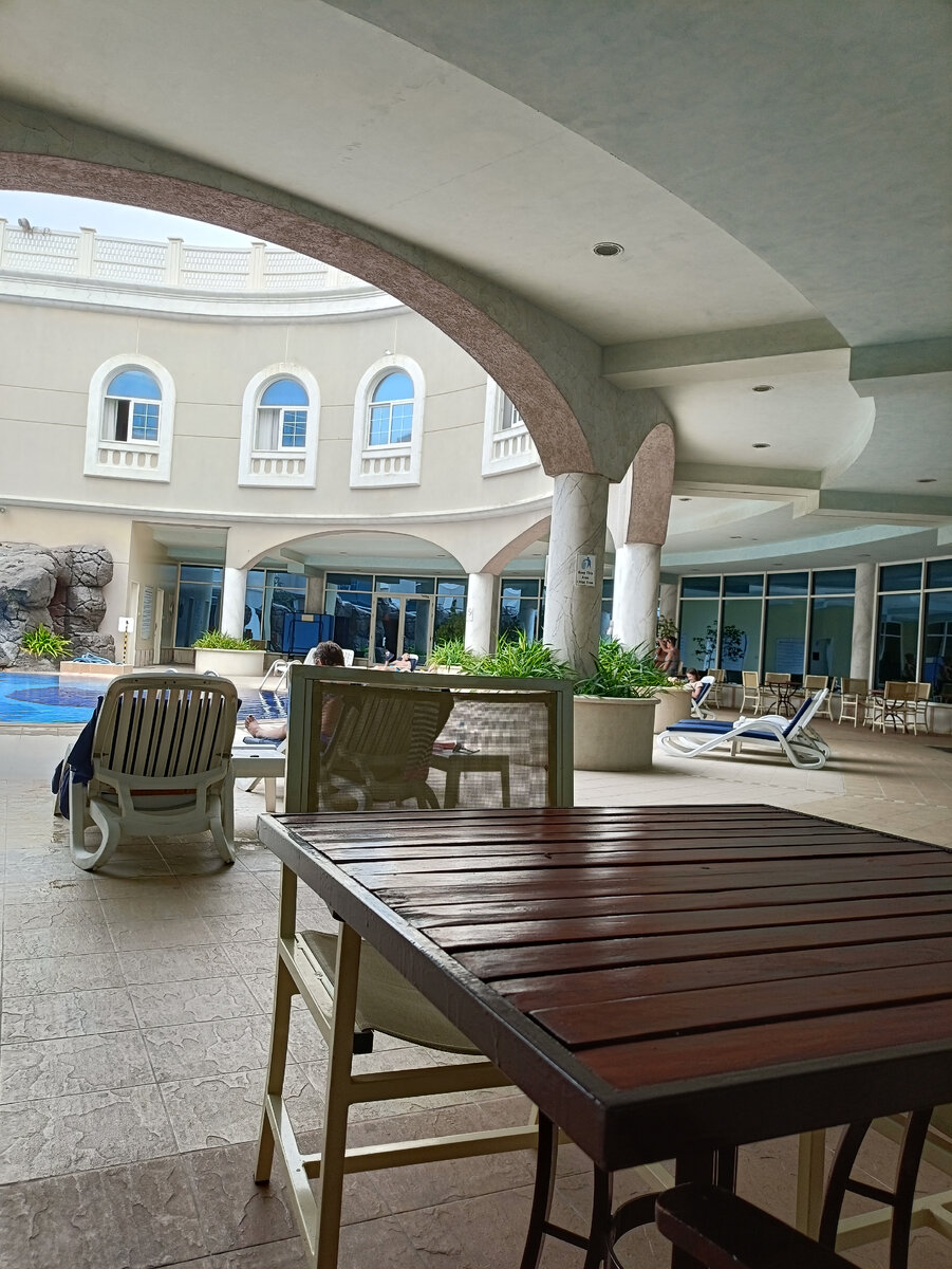 Тут есть такие столики и лежаки. Кто-то купается в бассейне