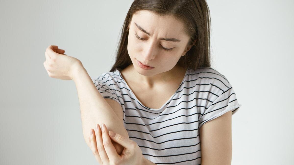    Девушка держится за локоть:Freepik / karlyukav