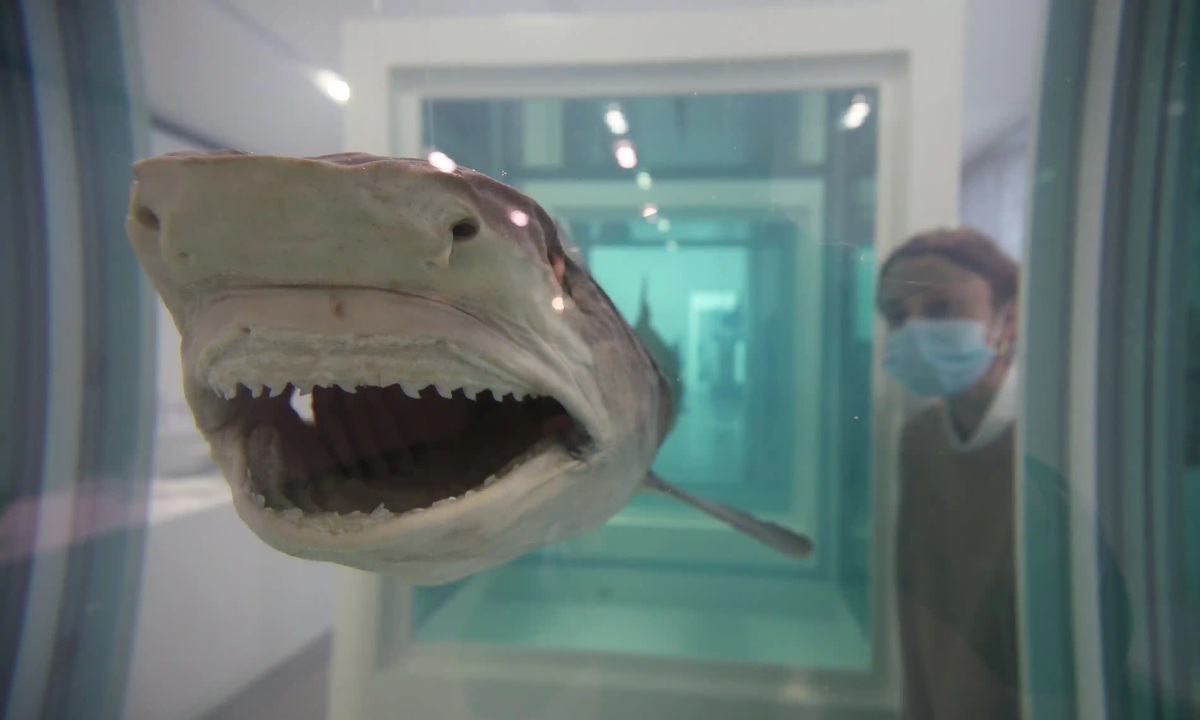 Сотрудник галереи рядом с картиной "Миф, исследованный, объясненный, взорванный" во время предварительного показа персональной выставки Херста "Конец века" в галерее Newport Street в Лондоне в 2020 году.