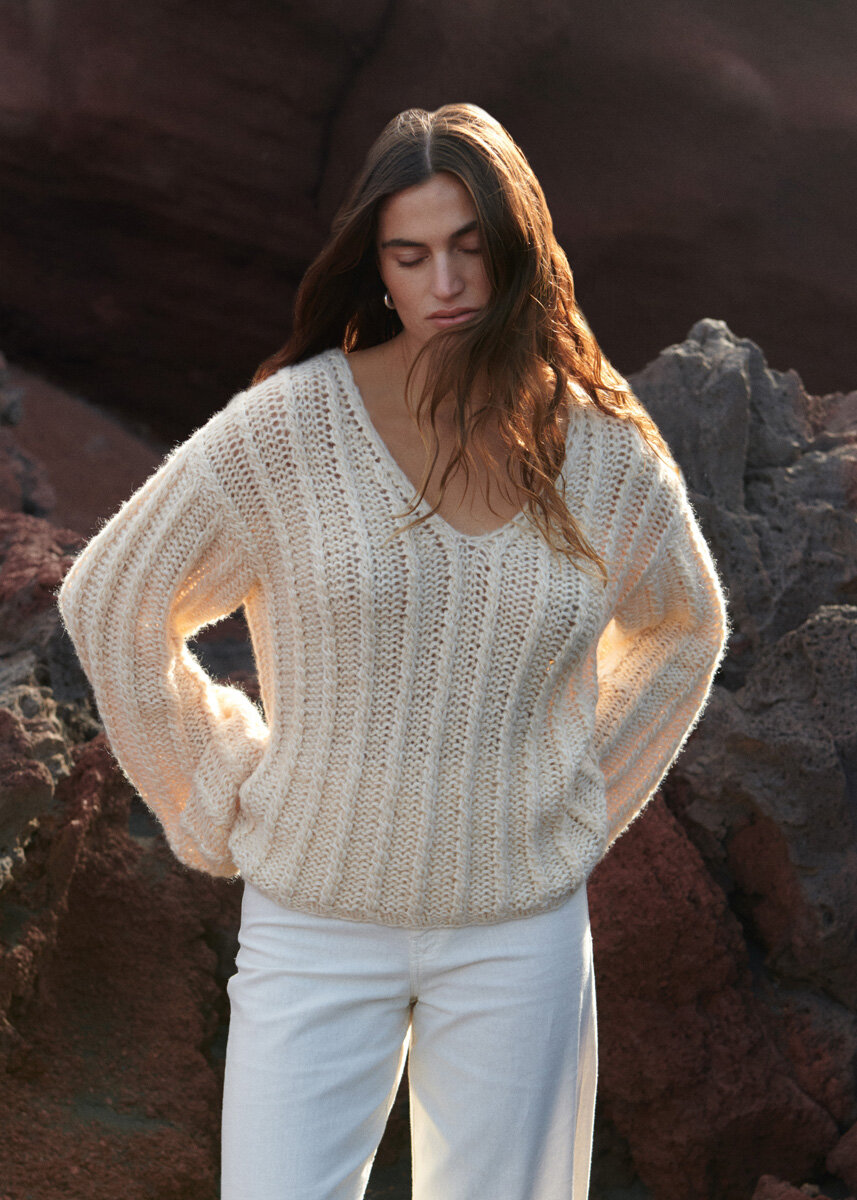 Стильный вариант пуловера с косами: глубокая V-образная горловина, свободная посадка и сверхдлинные рукава-баллон. Чтобы натуральный оттенок получился динамичнее, модель связана нитью в 4 сложения из разных видов пряжи.