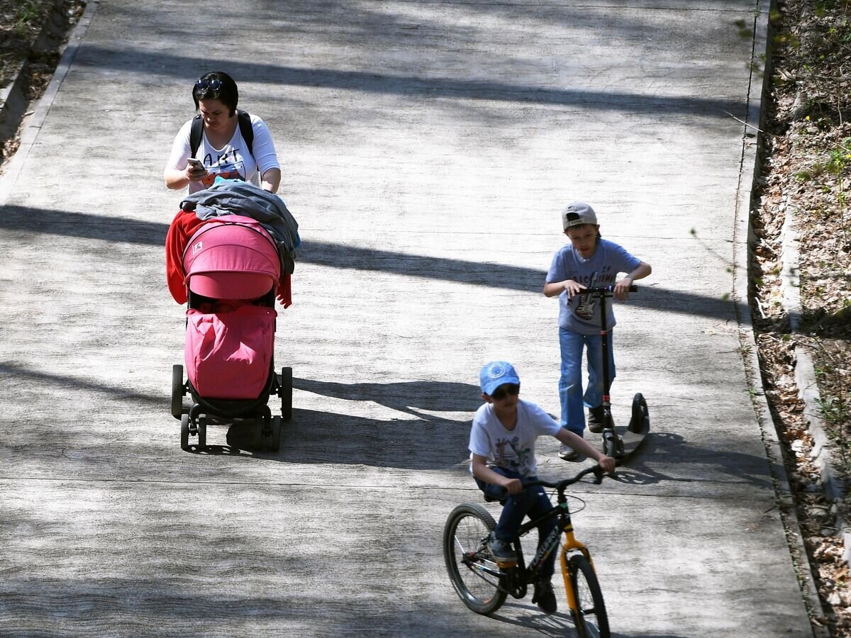    Женщина гуляет с детьми в парке© РИА Новости / Максим Богодвид