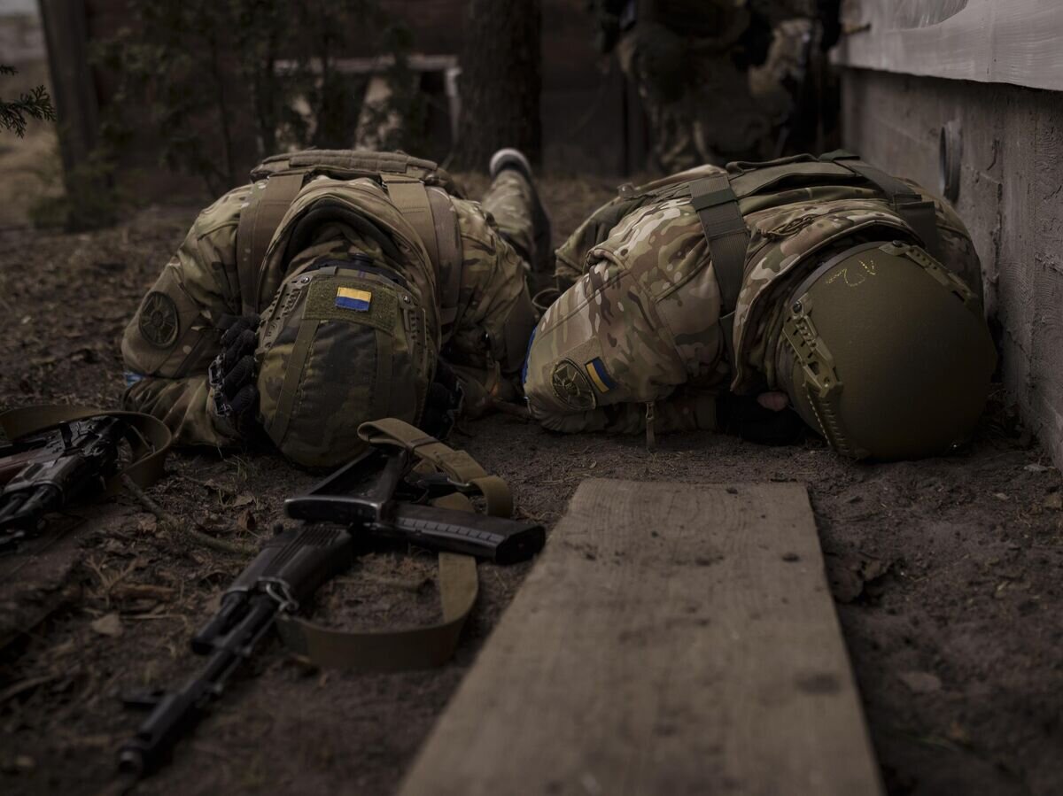    Украинские военнослужащие укрываются от артиллерийского огня© AP Photo / Felipe Dana