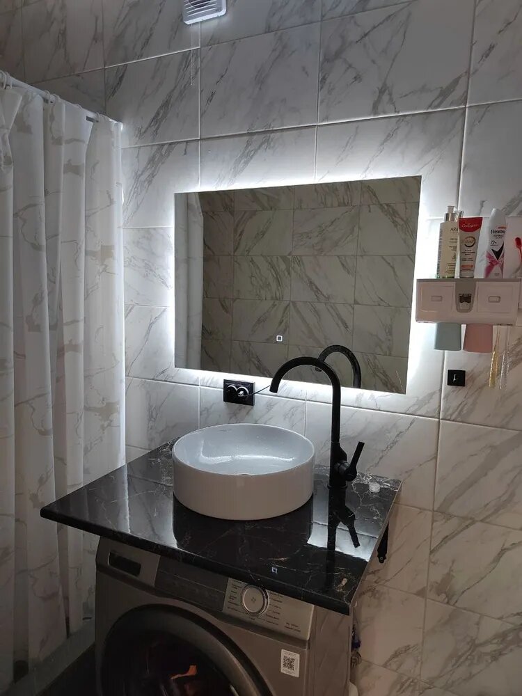 Фото реального отзыва с Озон. Зеркальное полотно бельгийского бренда AGC толщиной 4 мм, толщина подложки 16 мм, кромка зеркала шлифованная. Сенсорная кнопка с белой индикацией находится на высоте 13 см от нижнего края зеркала. Общая толщина зеркала 21 мм. Светодиодная лента в один ряд мощностью 9,6 Вт/м., 120 шт/м. Питание от сети 220В - 2 провода.