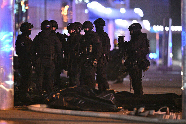 Сотрудники силовых структур около тел погибших у концертного зала «Крокус Сити Холл», где произошла стрельба, 22 марта 2024 года / Сергей Бобылев/РИА Новости   📷