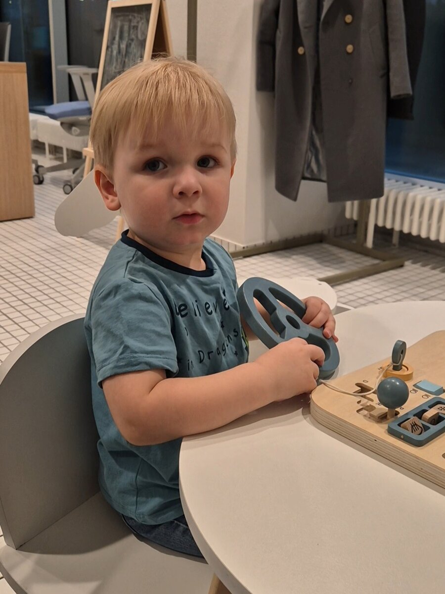 Гришка играет с бизи-бордом в клинике