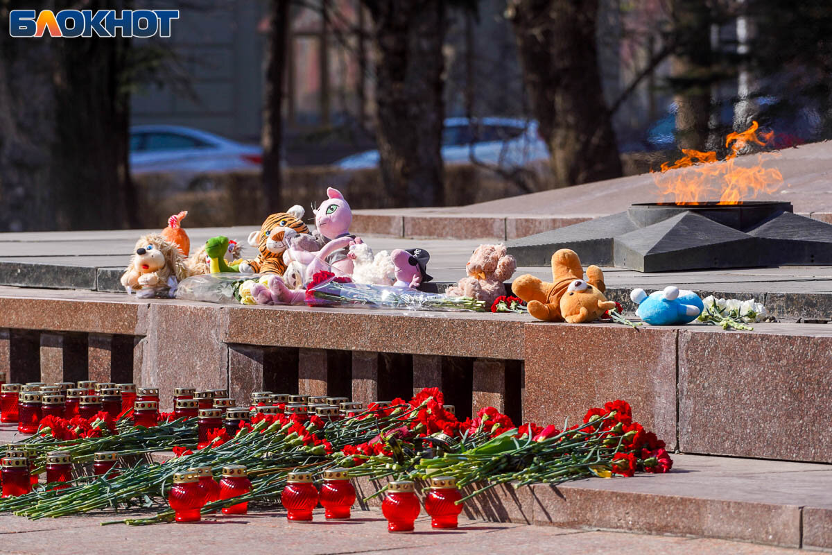 Многие волгоградцы признаются, что сегодня ощущают себя тревожно и предпочитают на выходить на улицу. На выходные все мероприятия в регионе отменены. Эту субботу все учебные учреждения провели с занятиями в дистанционном формате. ВГСПУ уже сообщил студентам, что очных парах у них не будет и в понедельник.Волгоград 23 марта вместе со всей страной скорбит по жертвам теракта в «Крокус Сити Холл», в котором по последним данным погибло 115 человек. Народный мемориал с лампадами, цветами и детскими игрушками появился у подножия Вечного огня. «Блокнот» показывает сплочение вокруг одной из крупнейших трагедий России.📷
📷
У Вечного огня из лампадок выстроили фразу «Мы вместе скорбим», которая быстро покрылась красными гвоздиками. В руках у многих пришедших на митинг можно заметить плакаты с надписями: «Мы вместе», «Скорбим со всей страной», упоминания «Крокус Сити» и дата — 22 марта.📷
📷
Возложить цветы на народный мемориал пришли взрослые с детьми, молодежь и старшее поколение. Скорбь каждый переживает по-разному: одни молятся за здоровье пострадавших, другие — ожидают скорейшего расследования теракта и наказания виновных.📷
📷
В телеграме уже появилось видео допроса одного из 11 подозреваемых в теракте.  Задержанный рассказал, что за теракт ему обещали полмиллиона рублей: половину заплатили, а остаток — по факту исполнения задания. Некто (якобы помощник проповедника) написал в телеграме, а позже предоставил оружие и назвал место нападения.— Что делал в Крокусе? — задает вопрос сотрудник спецслужбы.— Застрелил, — отвечает задержанный.— Кого?— Людей— За что?— За деньги.📷
📷
