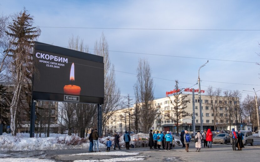    Жители Ижевска несут цветы и свечи к мемориалу. Фото: Сергей Грачев