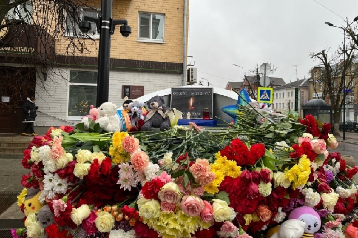    Тверичане несут цветы на мемориал на улице Трёхсвятской, несмотря на дождь