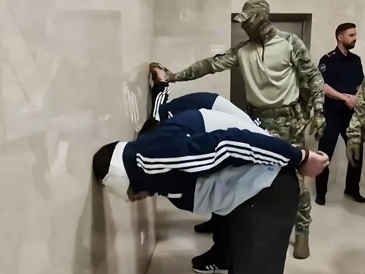    Задержанные по подозрению в террористическом акте в "Крокус Сити Холл" в здании центрального аппарата Следственного комитета РФ в Москве. Стоп-кадр видео© РИА Новости / Следственный комитет РФ
