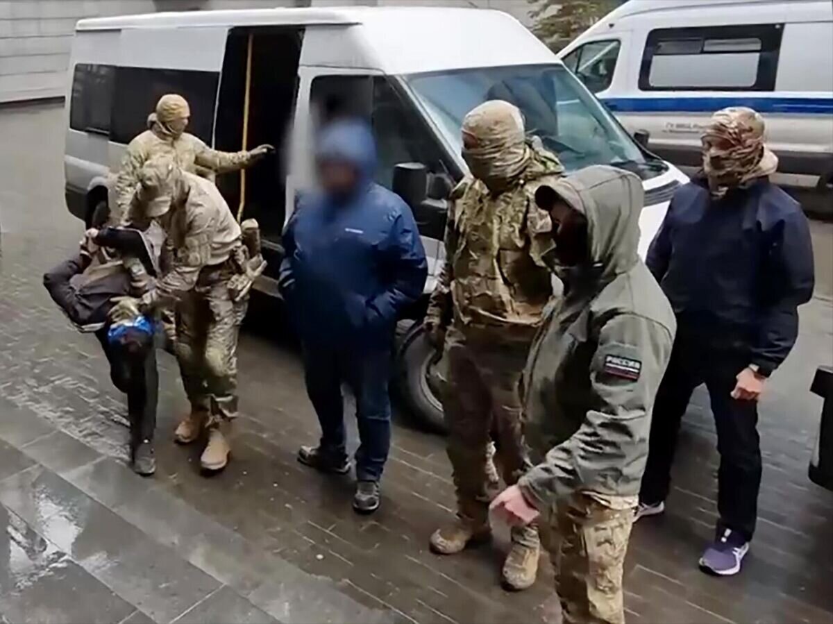    Один из задержанных по подозрению в террористическом акте в "Крокус Сити Холл" возле входа в здание центрального аппарата Следственного комитета РФ в Москве. Стоп-кадр видео© РИА Новости / Следственный комитет РФ