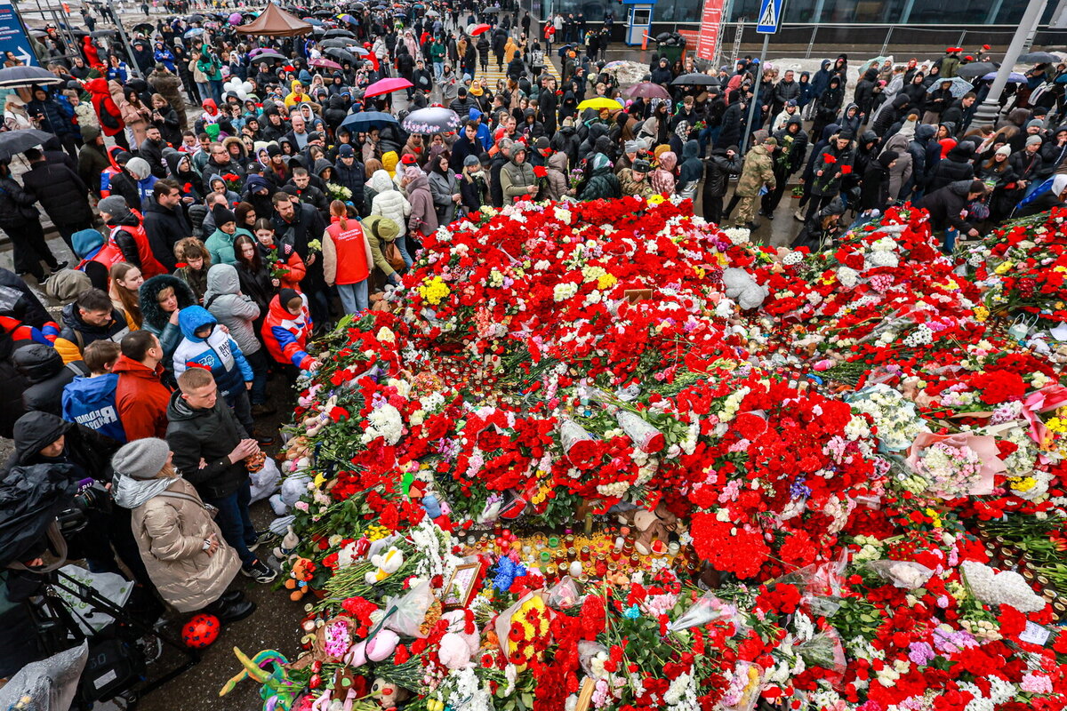 Люди у стихийного мемориала в память о погибших при теракте у здания концертного зала «Крокус Сити Холл», 24 марта 2024 года    📷