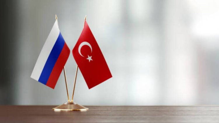    Russian and Turkish flag pair on desk over defocused background. Horizontal composition with copy space and selective focus. Nare