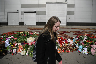    Девушка у стихийного мемориала у здания концертного зала "Крокус Сити Холл", где произошла стрельба и начался пожар. ©Сергей Бобылев РИА Новости