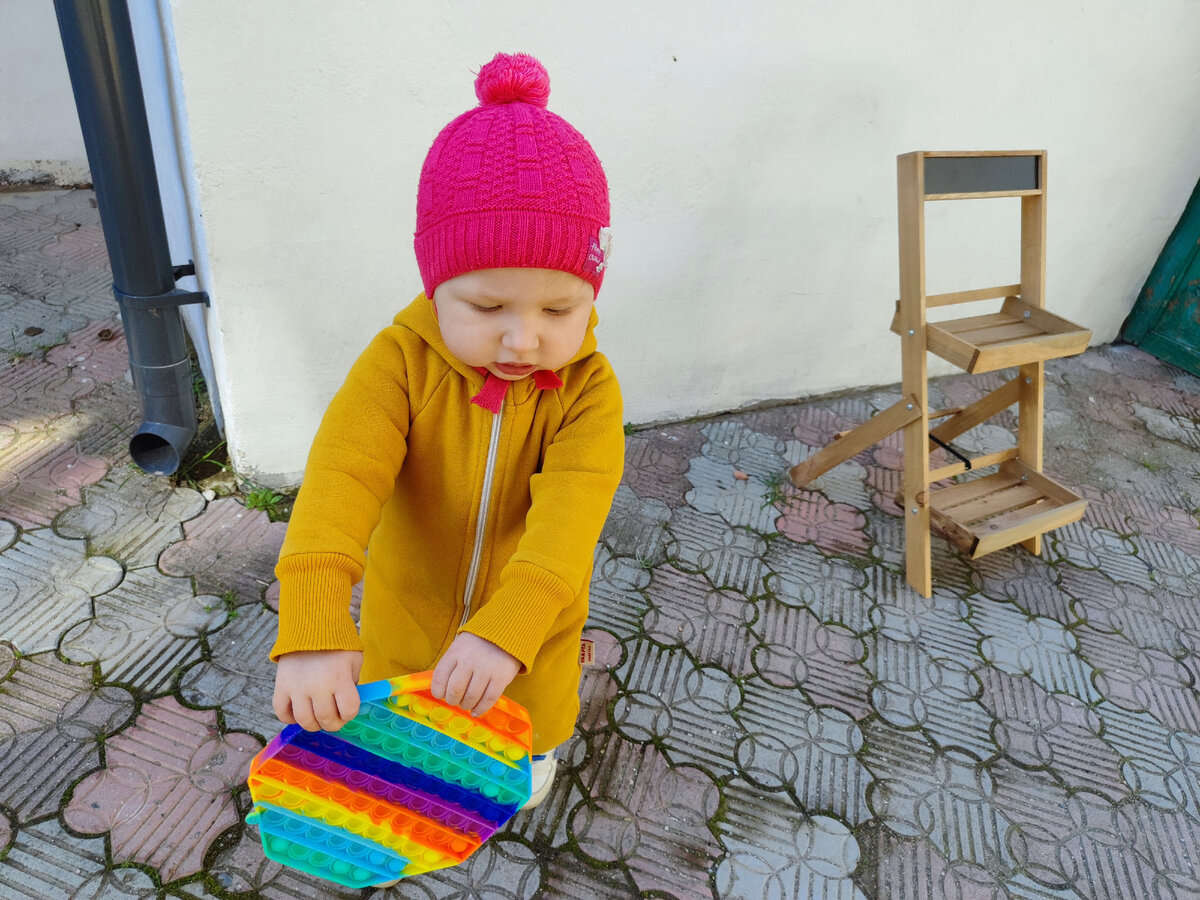 дочка гуляет во дворе. на заднем плане купила эту ерунду для цветов. 