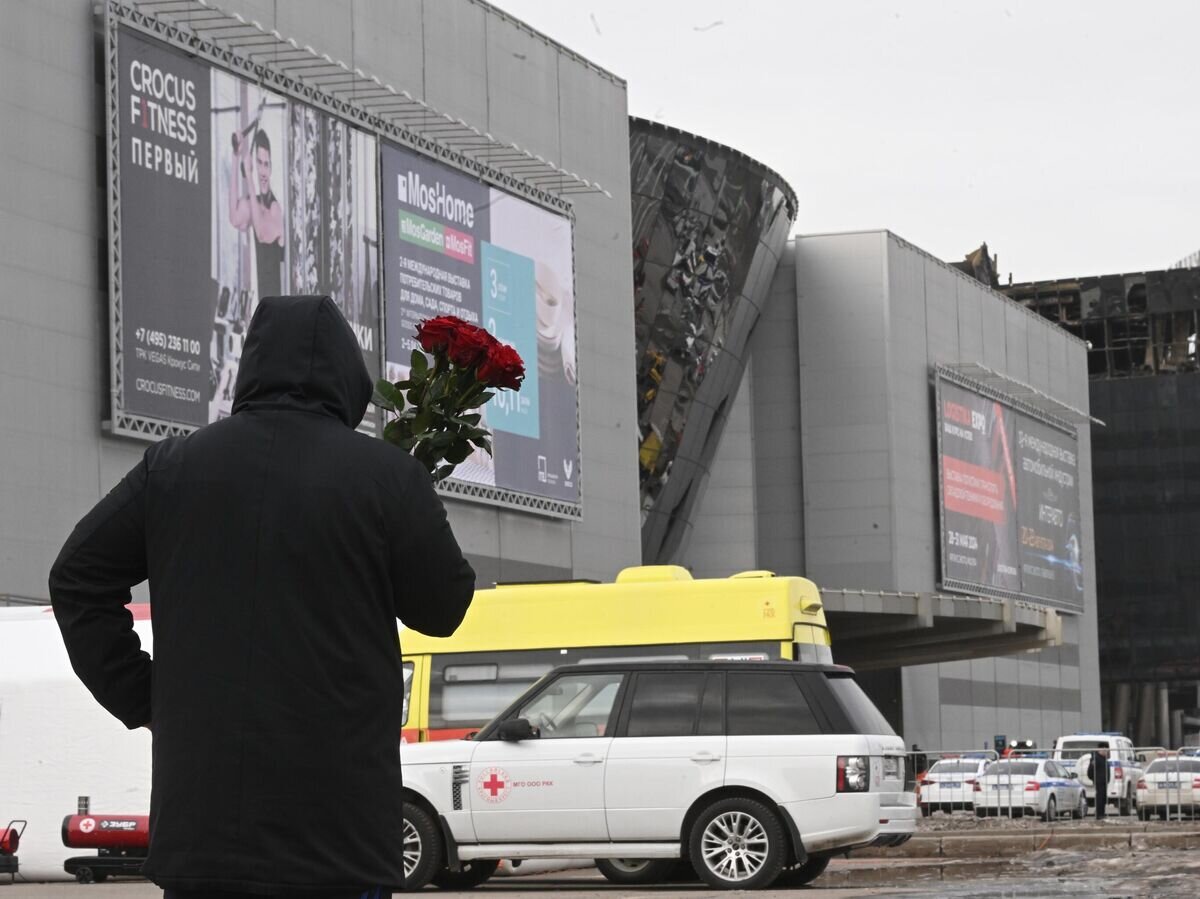 Мужчина с цветами у здания концертного зала "Крокус Сити Холл", где произошел теракт© РИА Новости / Кирилл Каллиников