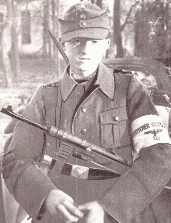 Юный фольксштурмовец с МП-40, в форме и с повязкой. Фото из книги.