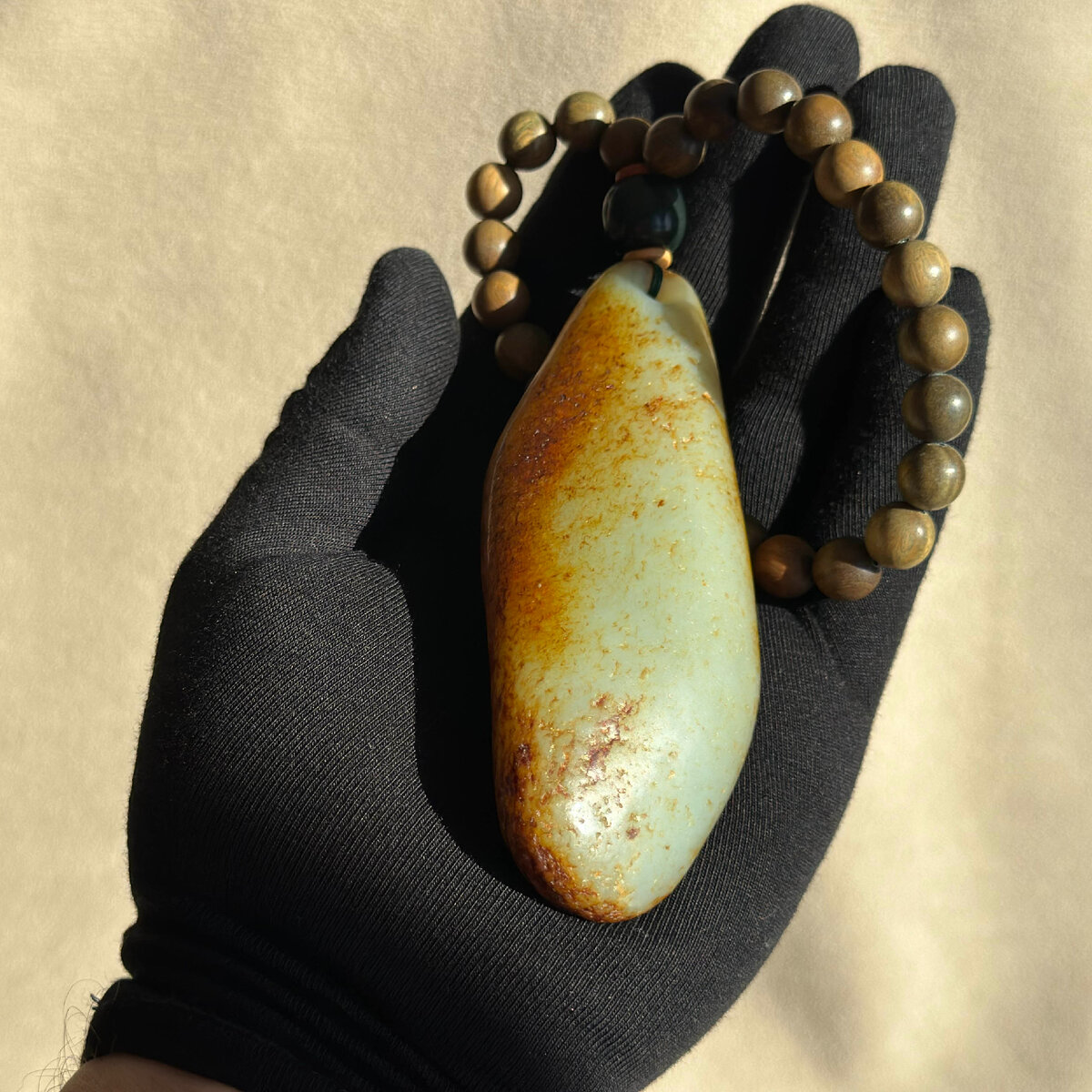 Галька нефрита с браслетом из зеленого сандала