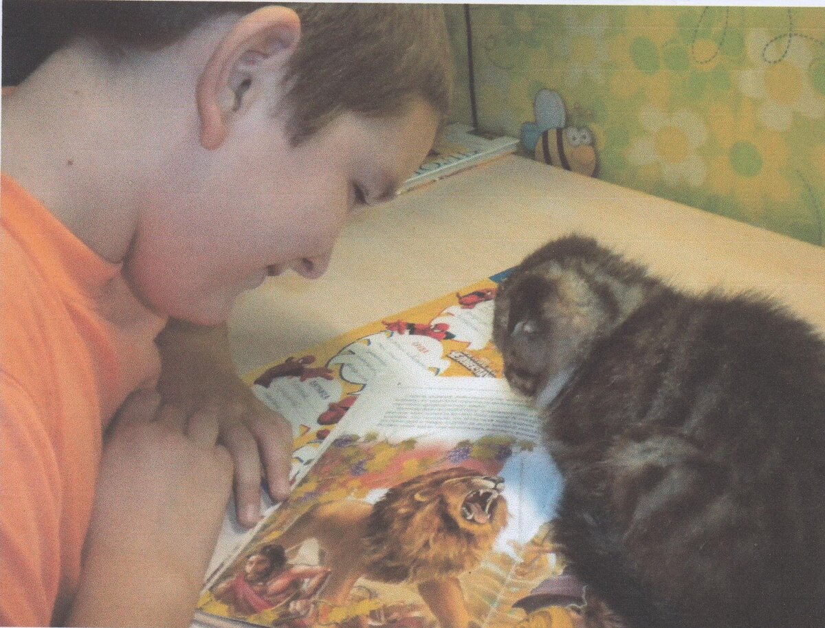 Артём (10 лет) читает книжку вместе с Барсиком.