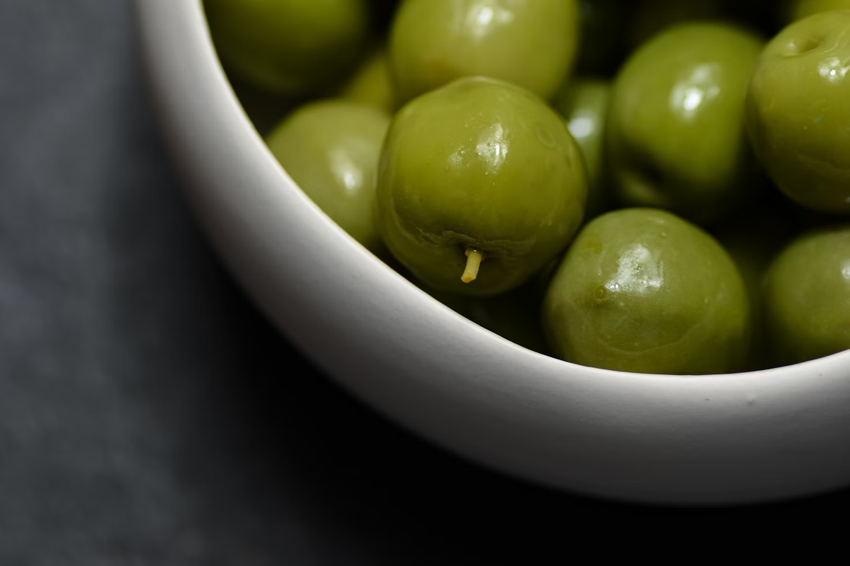 https://unsplash.com/photos/a-white-bowl-filled-with-green-olives-on-a-table-1Ek2sUGv8S4