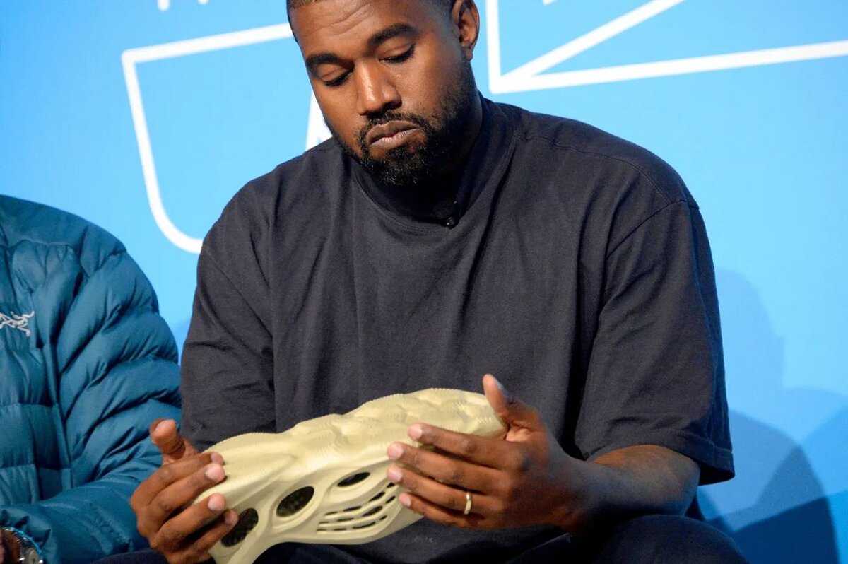 Западный репер Канье Уэст с парой кроссовок Yeezy в руках