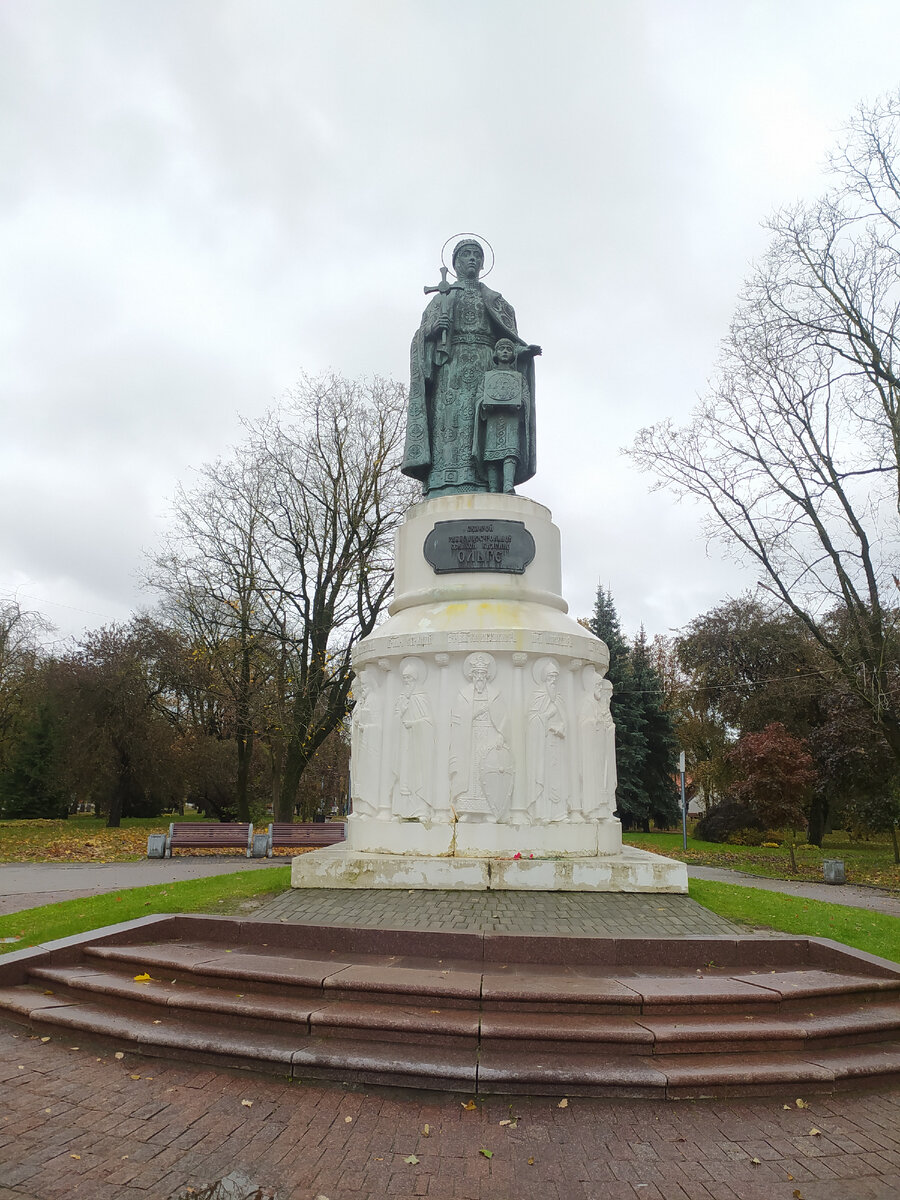  На высоком белом постаменте, окруженном барельефами 12 псковских святых, высится фигура женщины с нимбом над головой. В правой руке она держит крест, левая словно благословляет прижавшегося к ее ногам мальчика, который прижимает к груди образ Спаса Нерукотворного. Это княгиня Ольга с внуком Владимиром. /фото автора