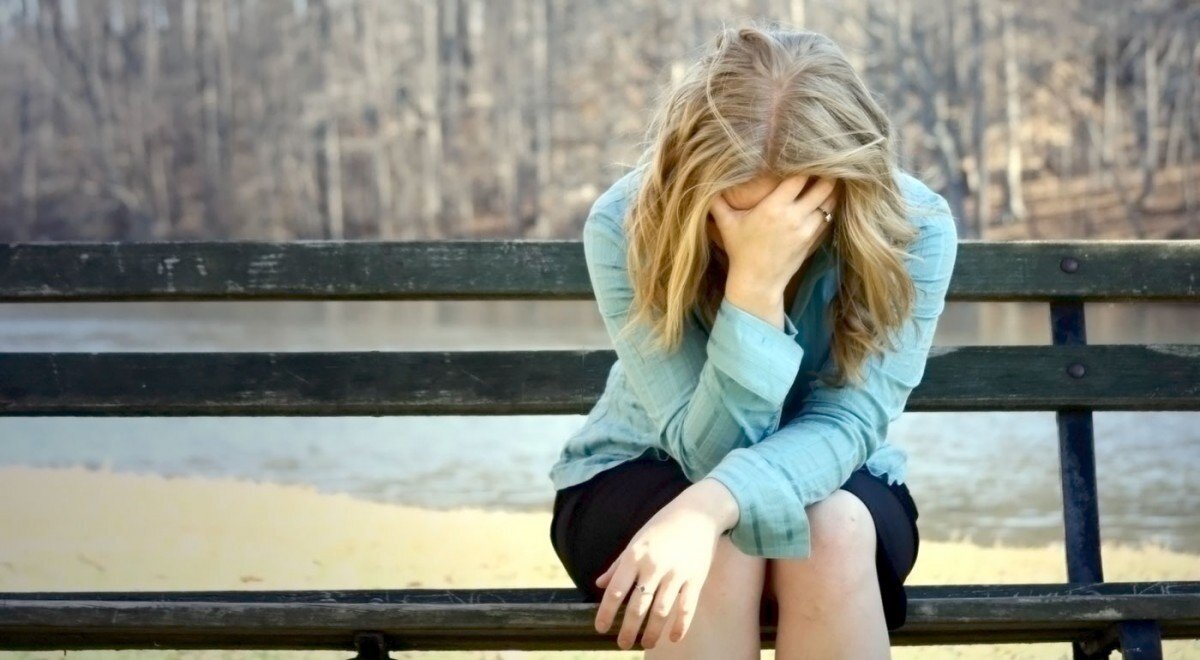 На скамье. У этой молодой и внешне здоровой девушки психологические проблемы и стресс.