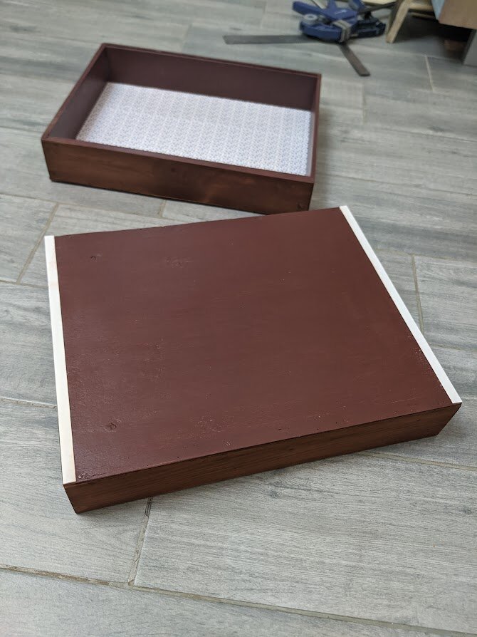 дно ящиков внутри оклеено оберточной бумагой, снаружи покрашено и для легкого выдвижения прилеены пластиковые полоски