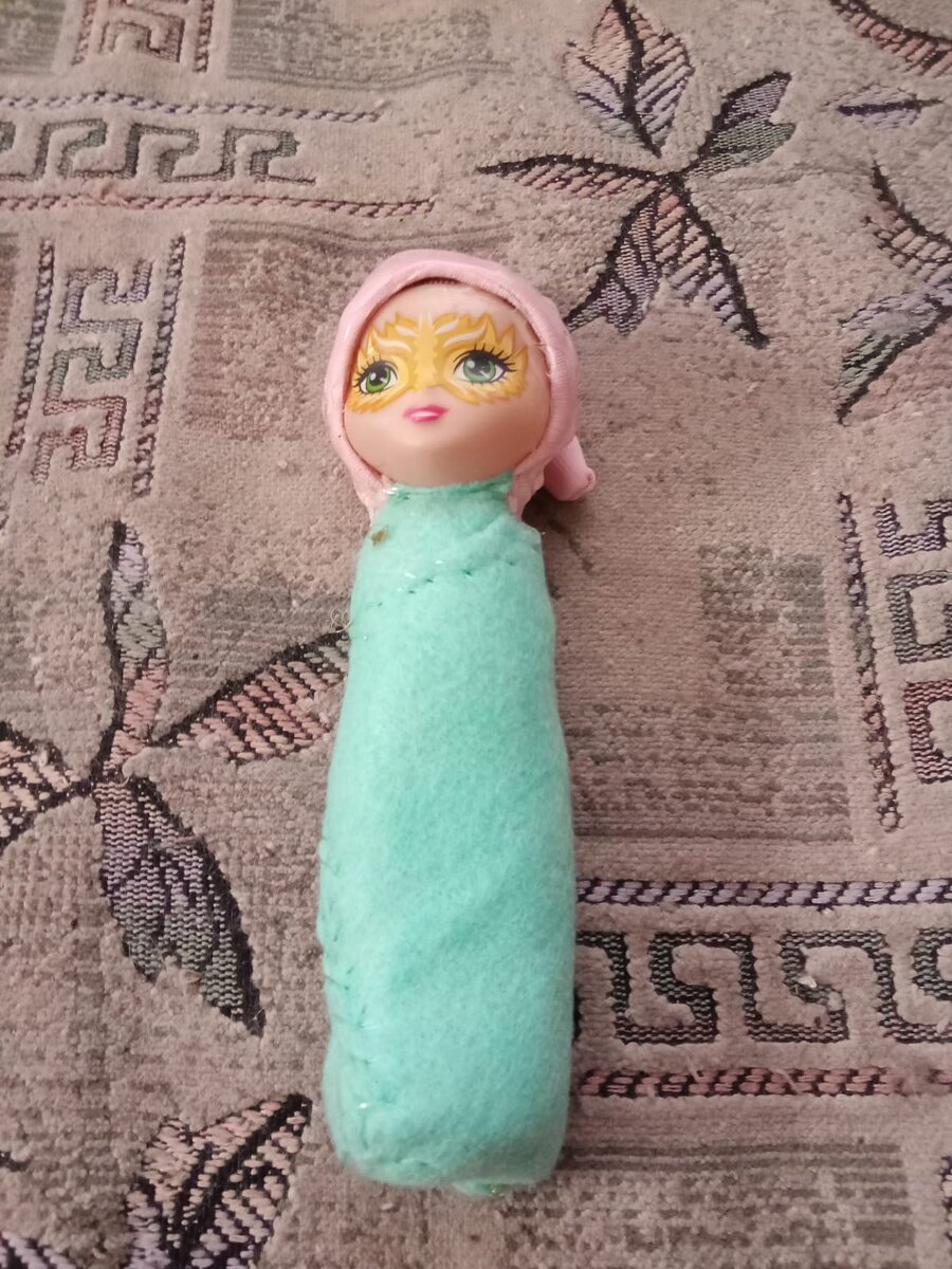  Эта куколка  малышка . Ее одели в колпачок . И завернули  в  пленку .